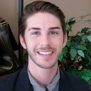 Smiling young man with short dark hair and facial hair